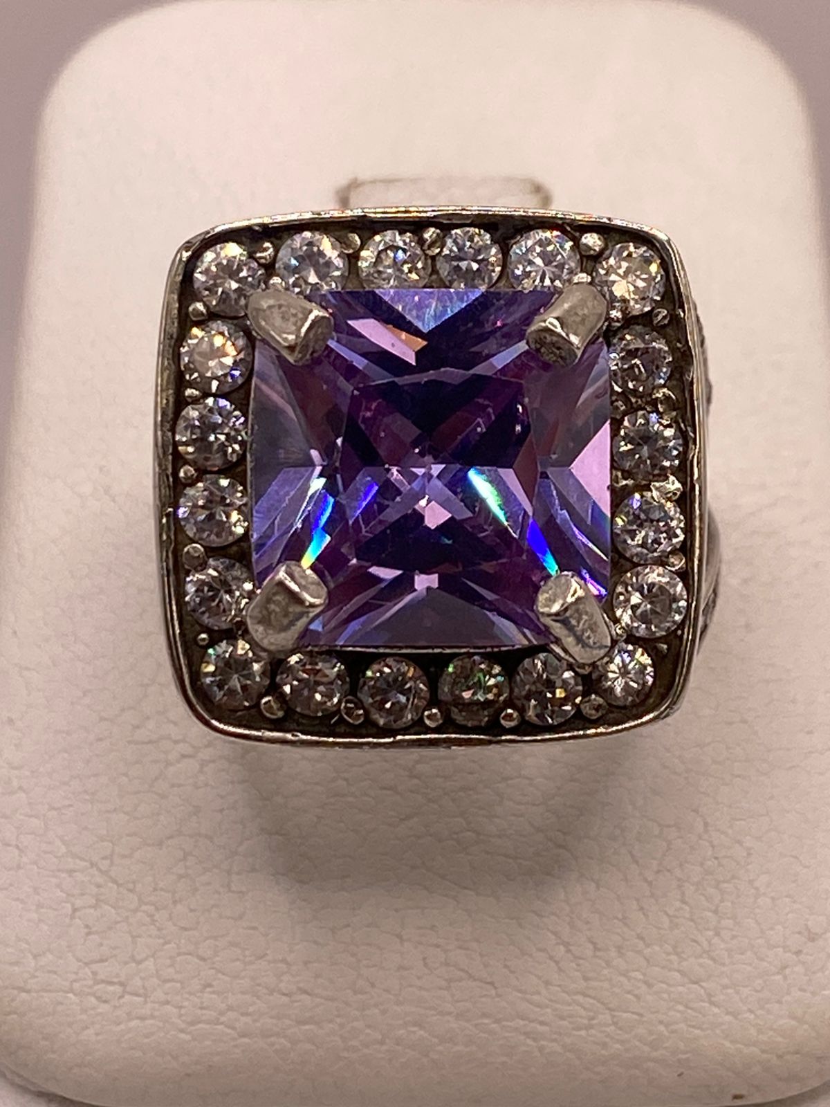 Solitario de plata .925 con zirconia morada, halo y banda pavimentada sobre fondo neutro — joyería artesanal Taxco
