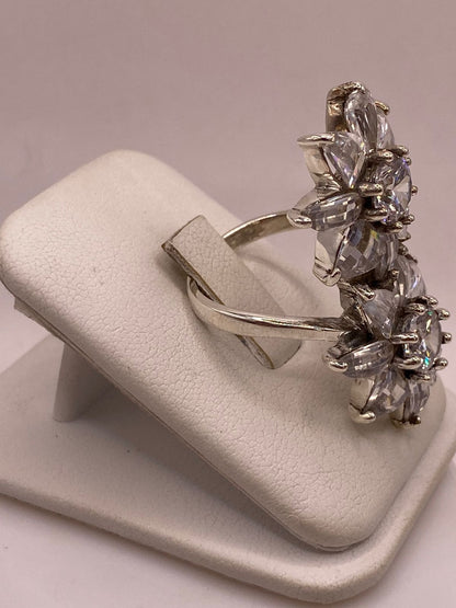 Anillo doble flor de plata .925 con pétalos de circonia gota y centros redondos sobre fondo neutro — joyería artesanal Taxco