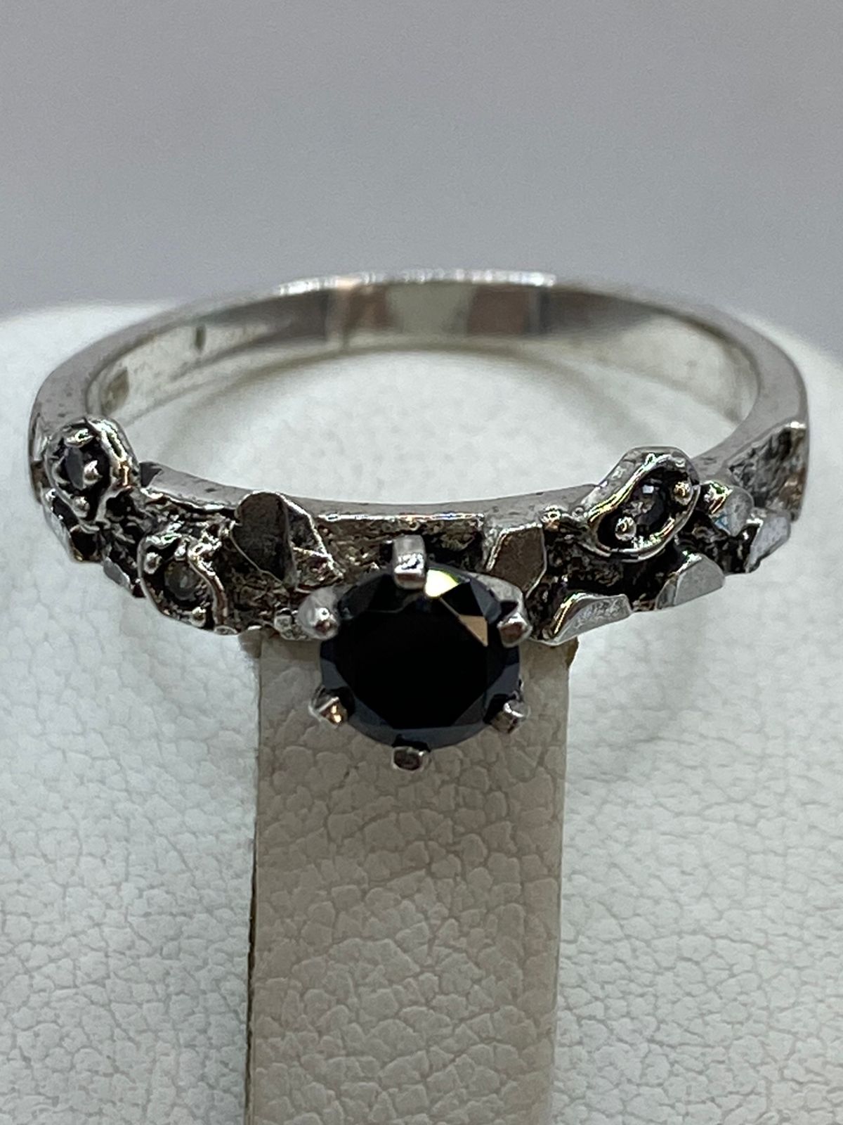 Close-up de circonia negra engastada en anillo artesanal de plata oxidada, Arte Taxco