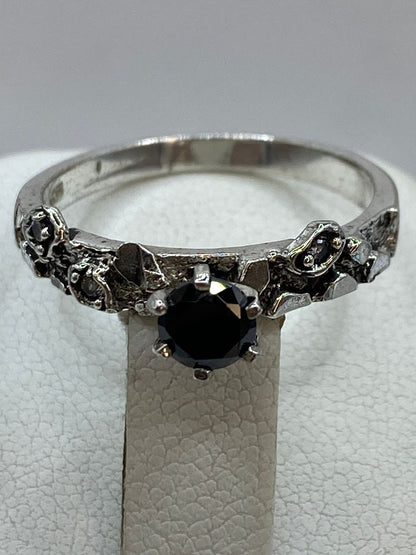 Close-up de circonia negra engastada en anillo artesanal de plata oxidada, Arte Taxco