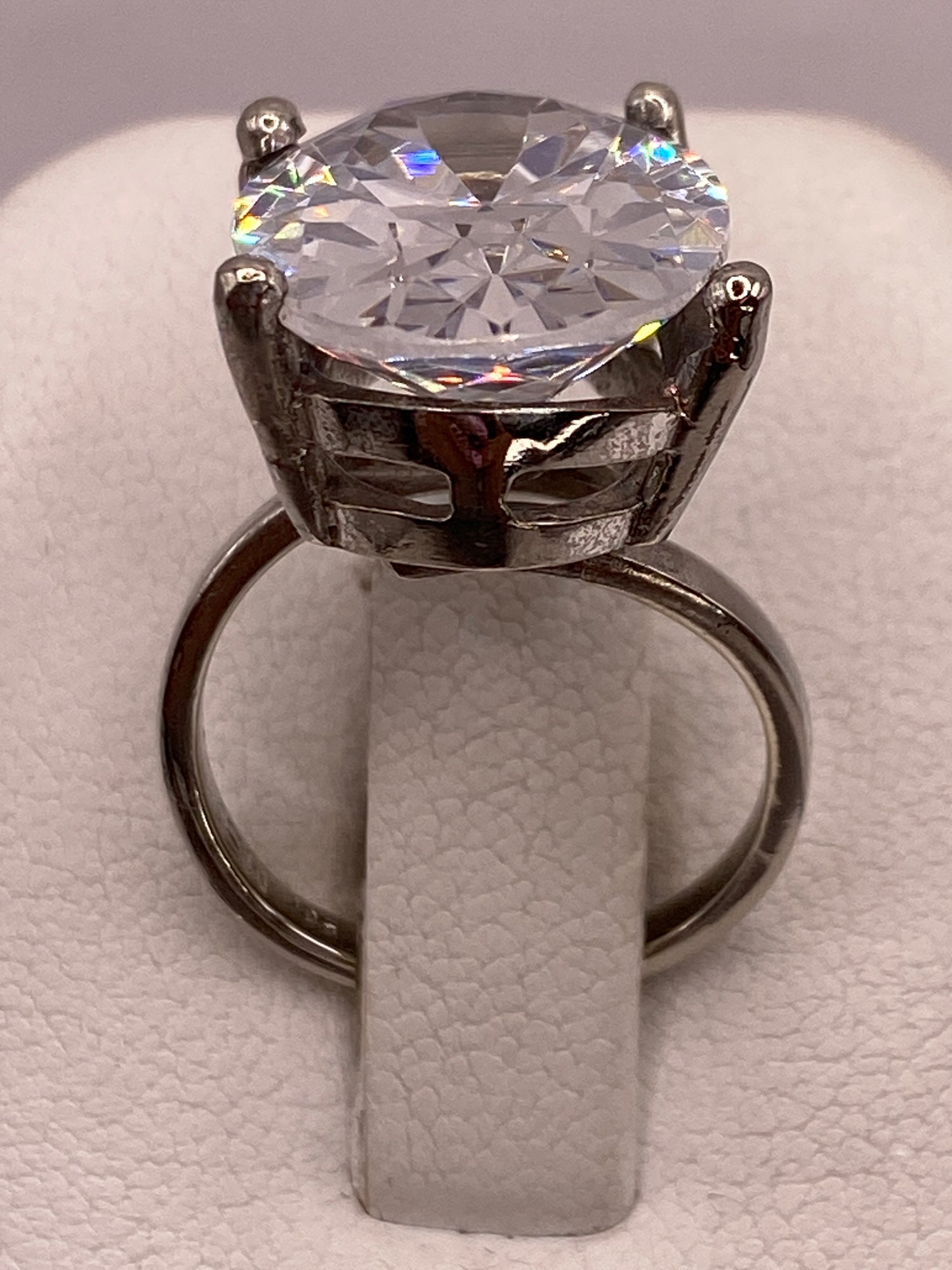 Anillo de plata solitario con circonia cristalina grande en la mano de una mujer