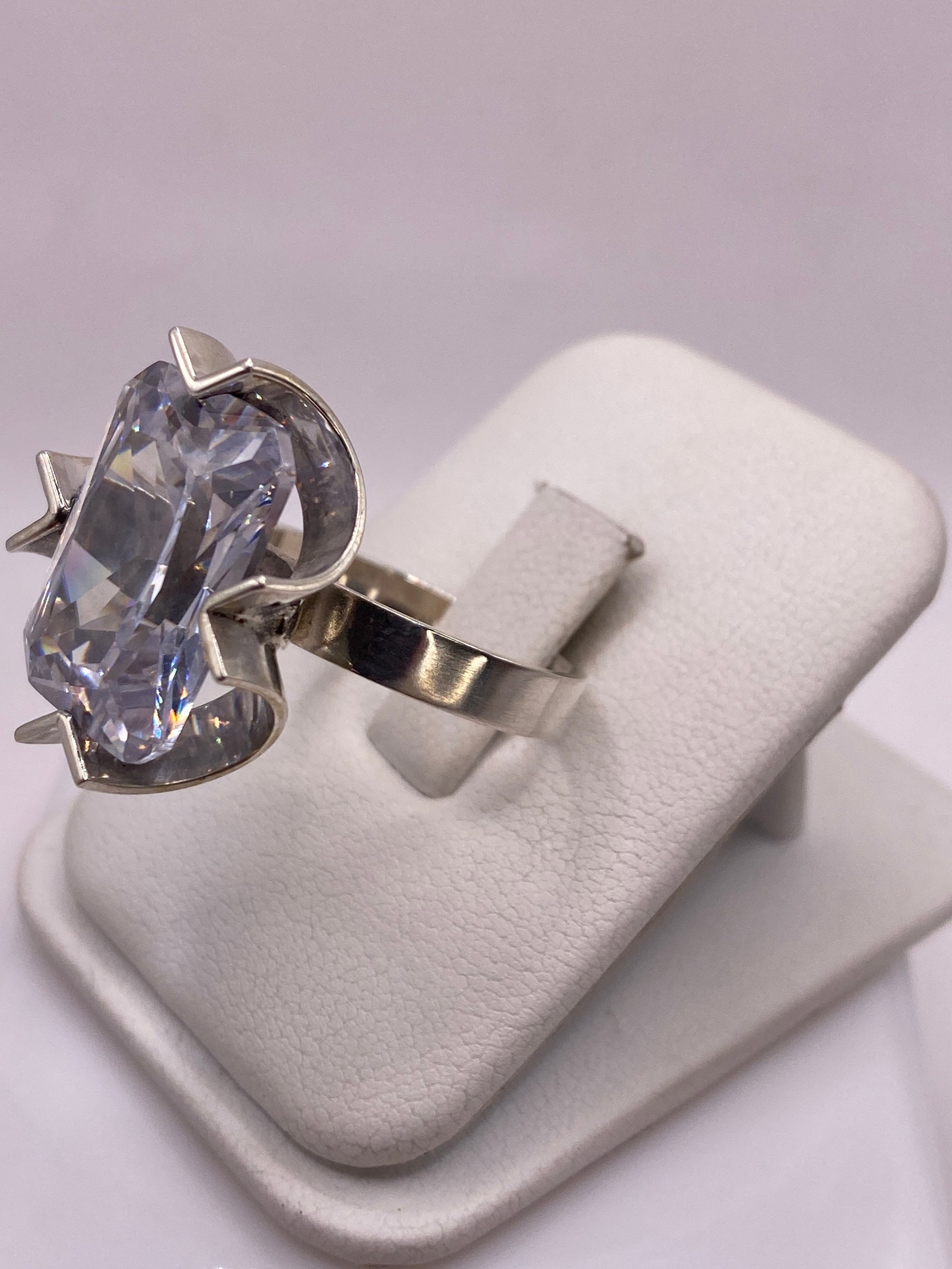 Anillo solitario en plata .925 con brazos en V mostrando la circonia brillante en la mano