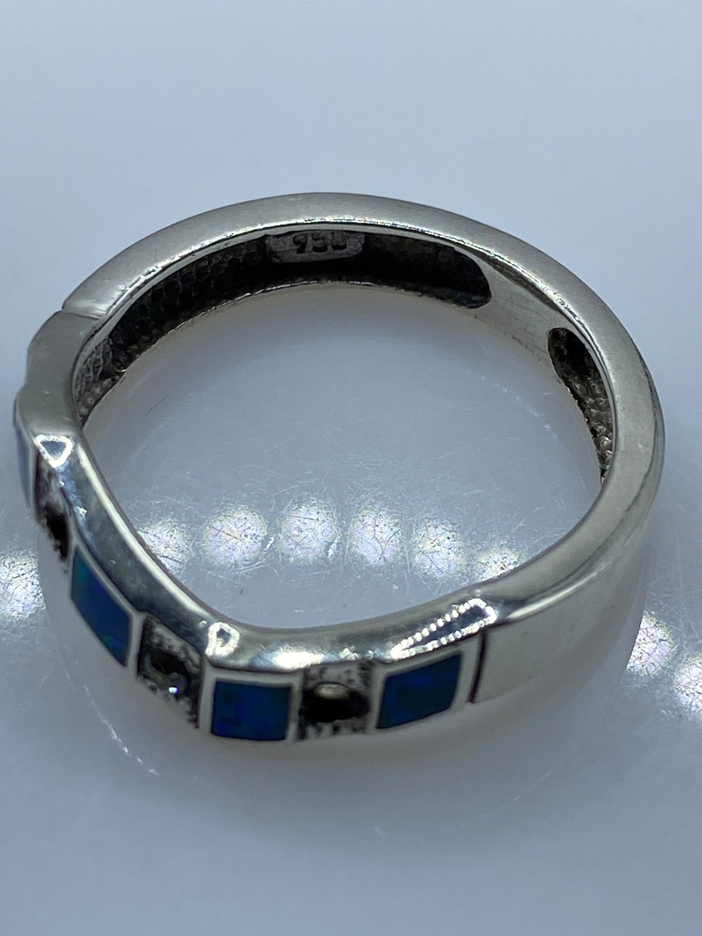 Anillo de plata .950 en dedo de mujer mostrando destellos azules del ópalo natural