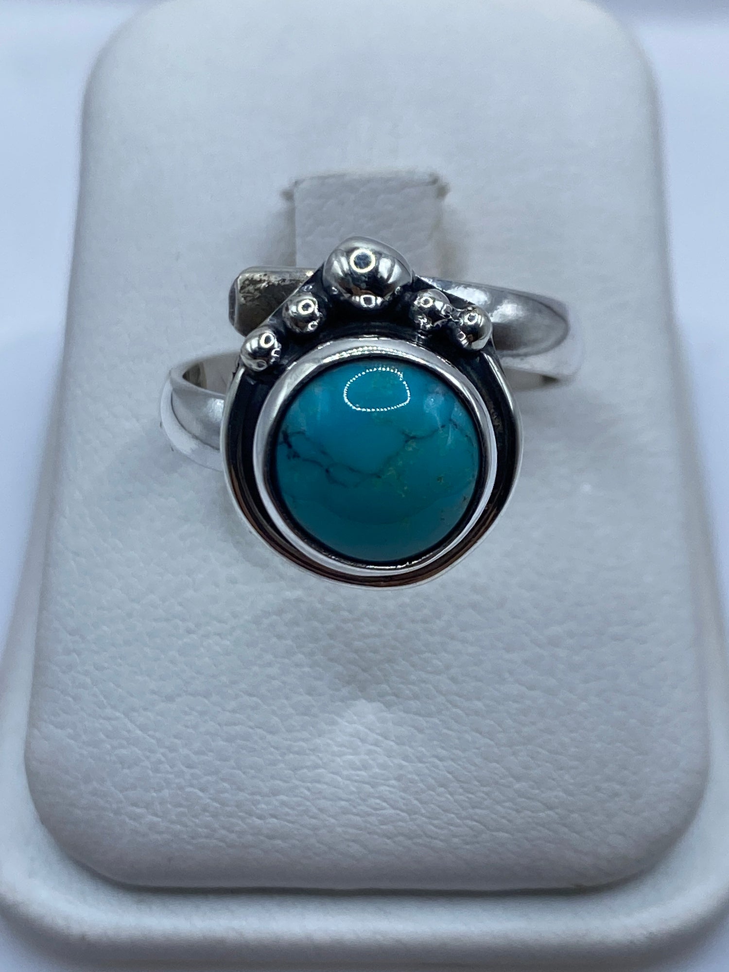 Anillo de turquesa azul cielo con esferas de plata .925 en la mano de una mujer