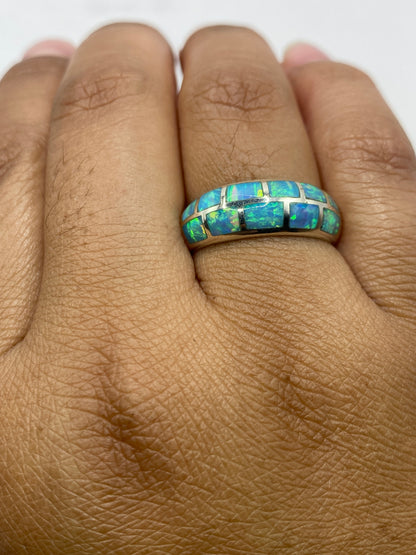 Anillo de ópalo de fuego en la mano mostrando el fuego interior azul cielo