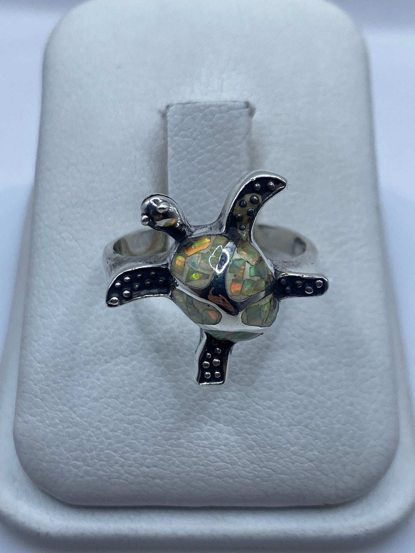 Anillo de plata .950 con ópalo de fuego natural mostrando colores ámbar, verde y rojo en luz natural