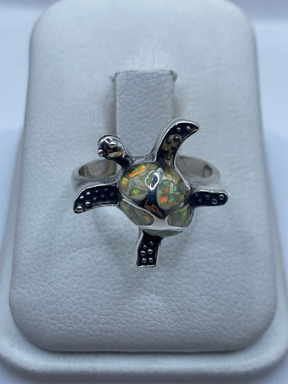 Anillo de plata .950 con ópalo de fuego natural mostrando colores ámbar, verde y rojo en luz natural