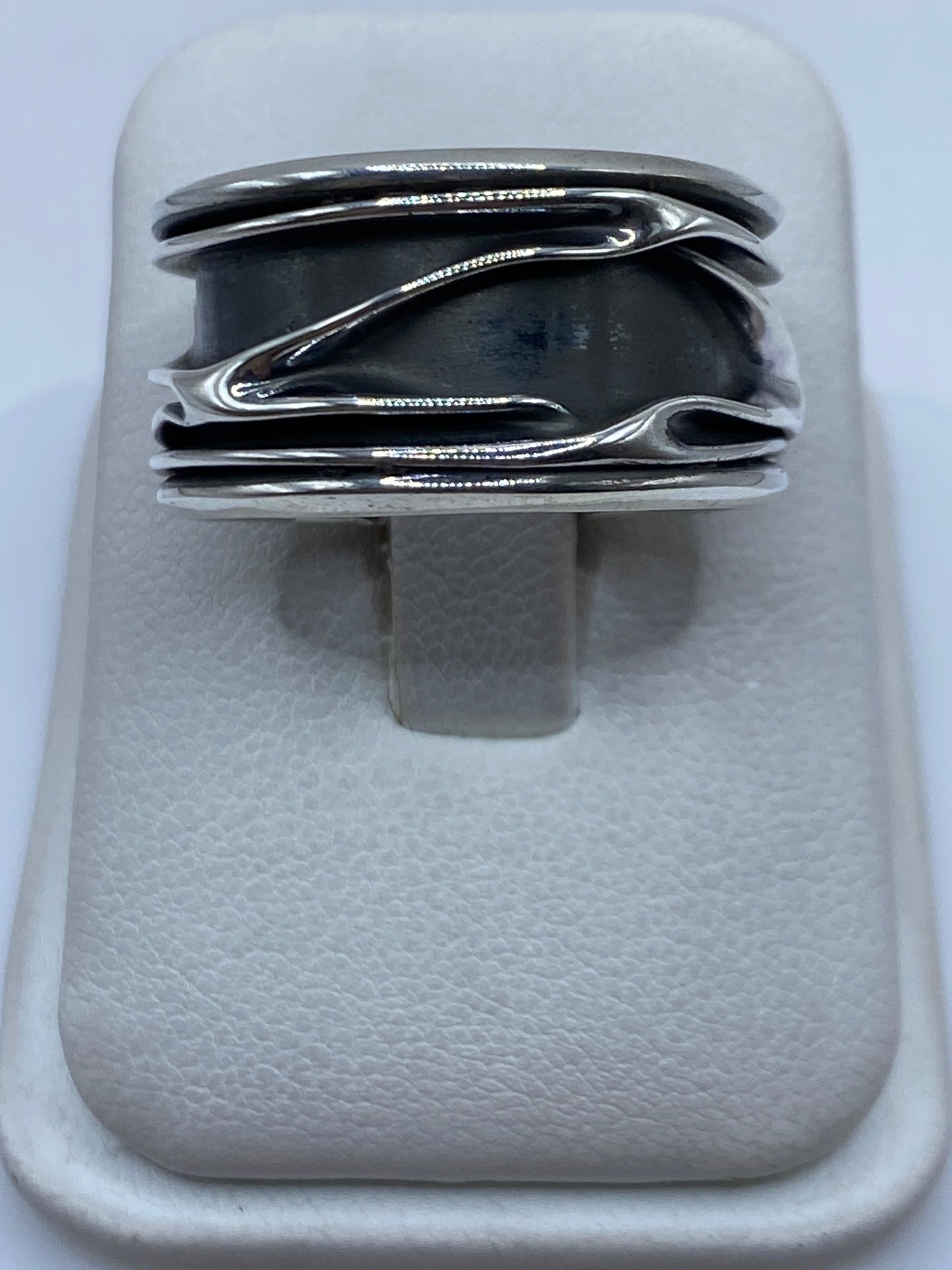 Anillo de plata .925 con bandas superpuestas en vista superior, mostrando el pulido detallado