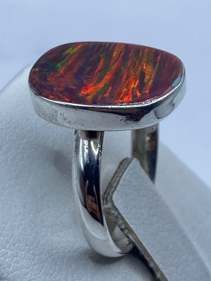 Anillo de plata ópalo de fuego en la mano de mujer revelando brillo natural