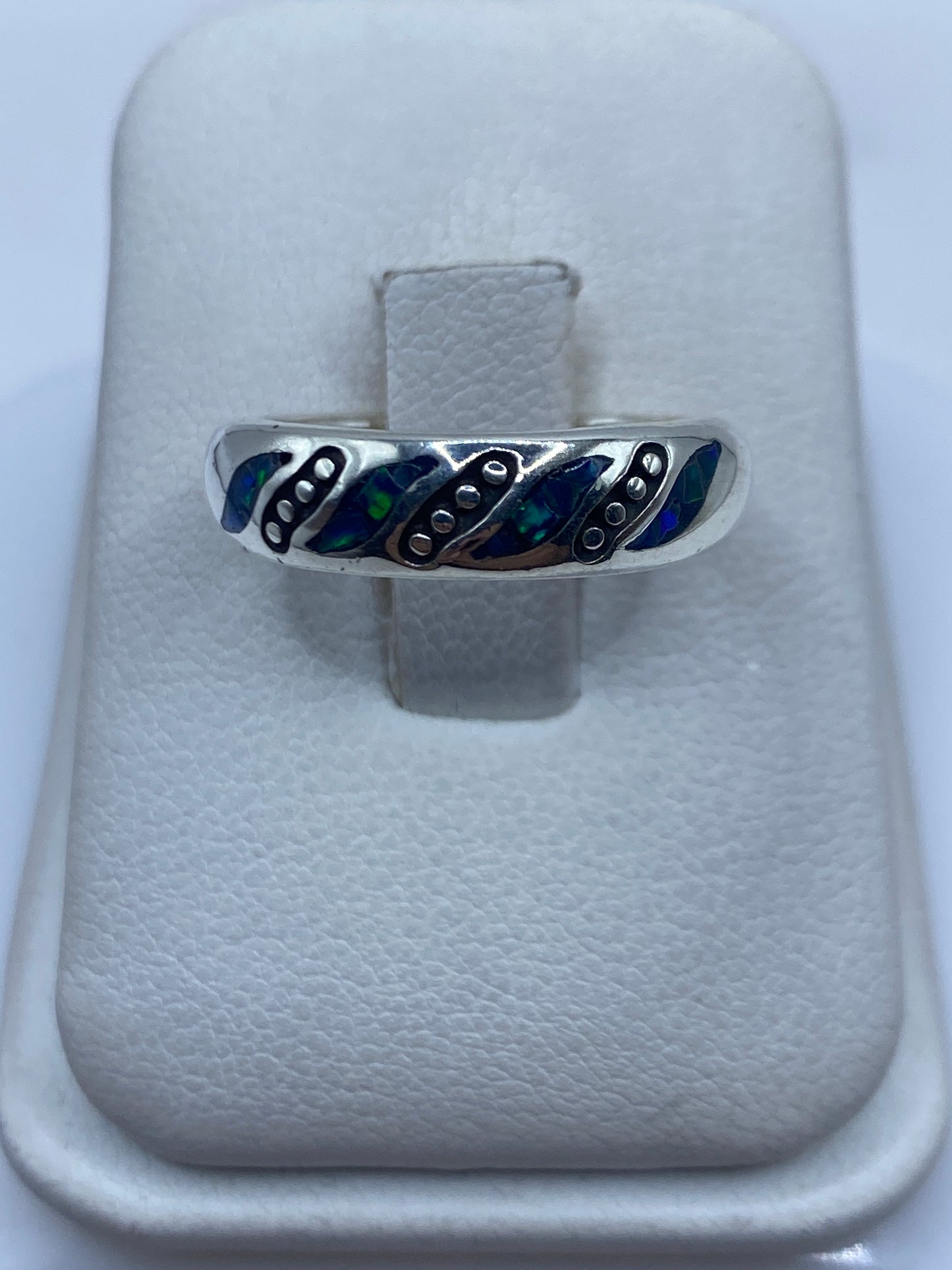 Anillo minimalista de plata .950 con ópalo de fuego azul natural, vista frontal sobre cojín blanco