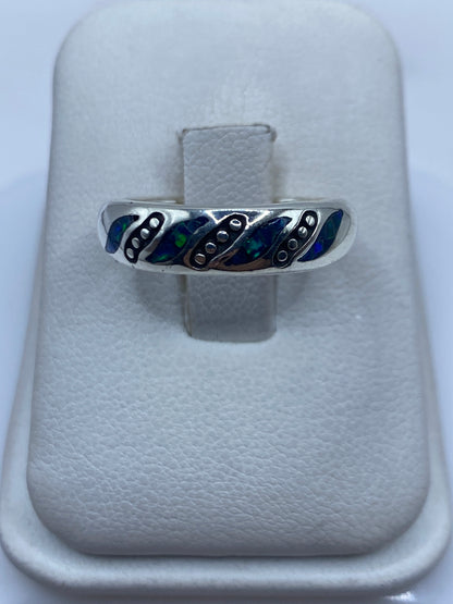 Anillo minimalista de plata .950 con ópalo de fuego azul natural, vista frontal sobre cojín blanco