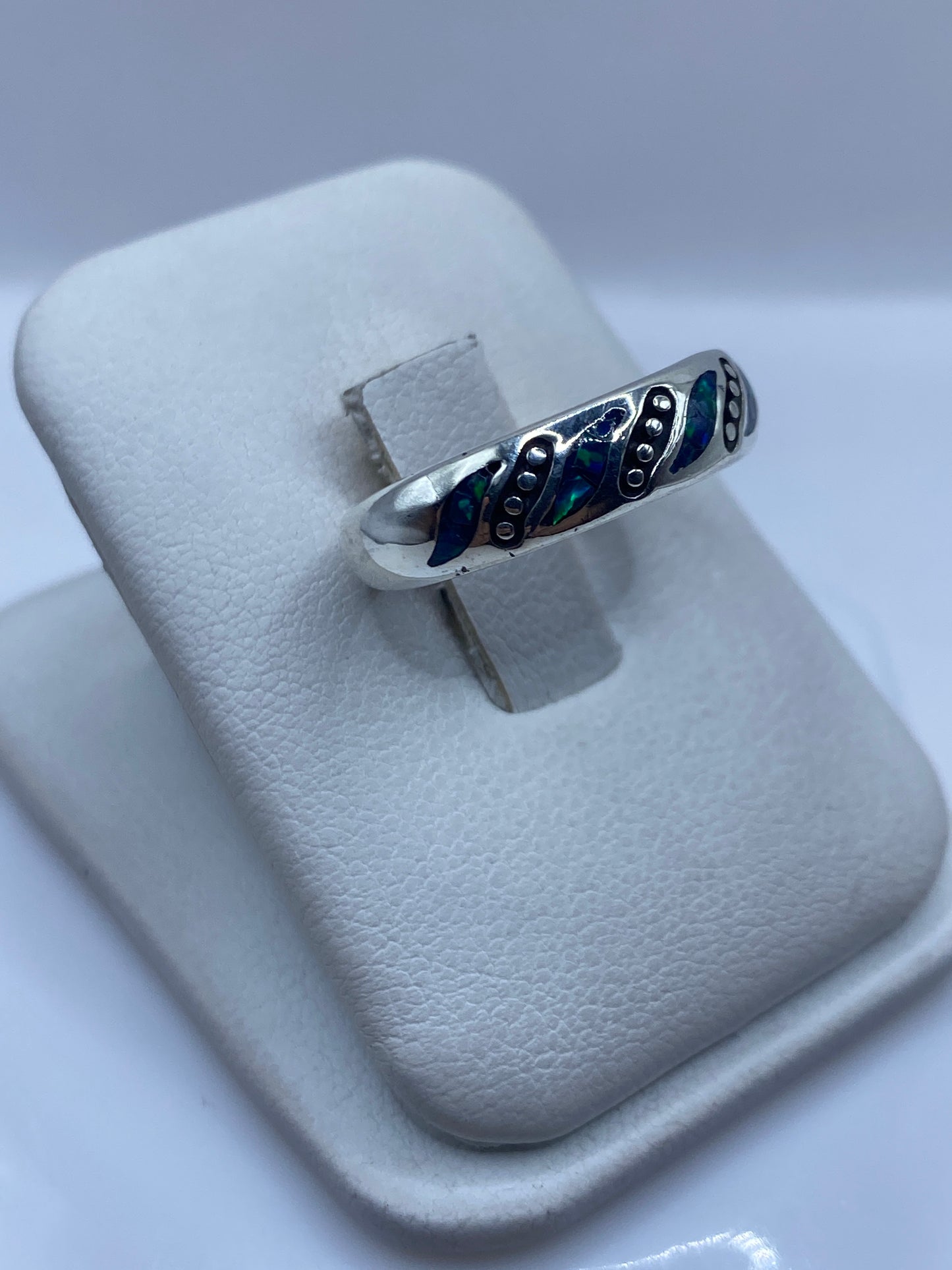 Detalle lateral del anillo mostrando las incrustaciones de ópalo azul y verde en plata pura