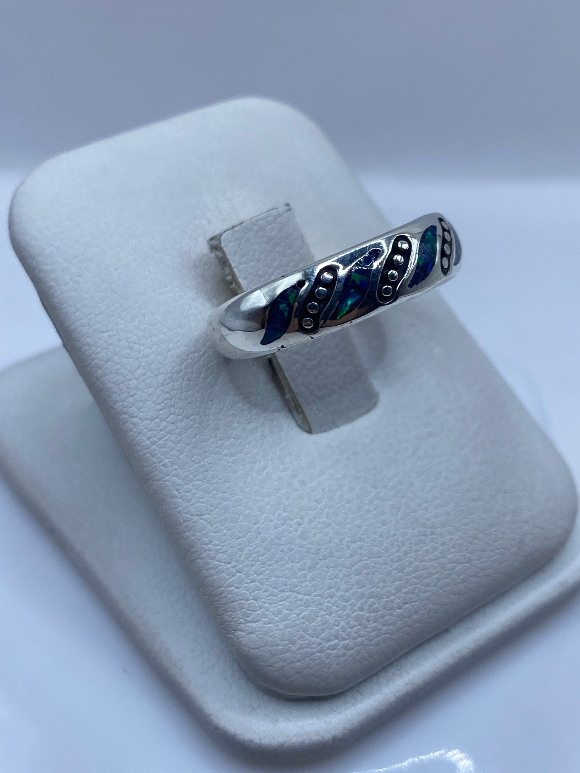 Detalle lateral del anillo mostrando las incrustaciones de ópalo azul y verde en plata pura