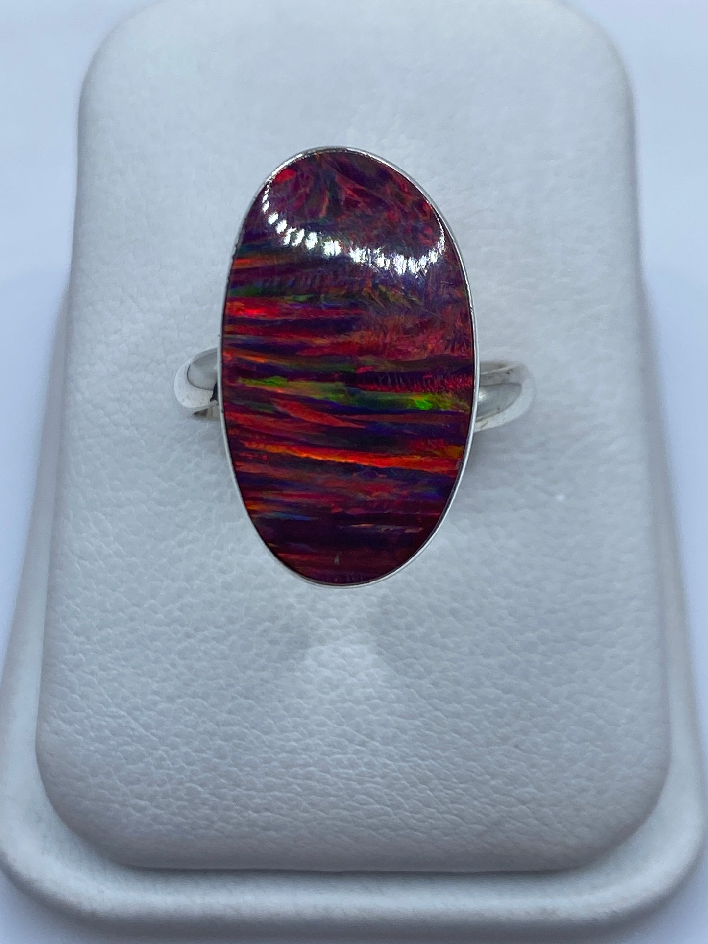Anillo de plata .950 con ópalo de fuego multicolor en forma ovalada, frente de joyero