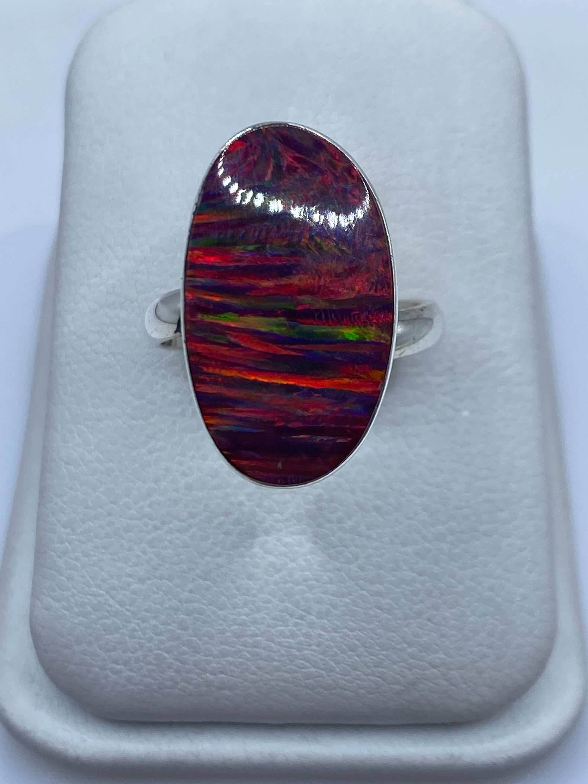 Anillo de plata .950 con ópalo de fuego multicolor en forma ovalada, frente de joyero