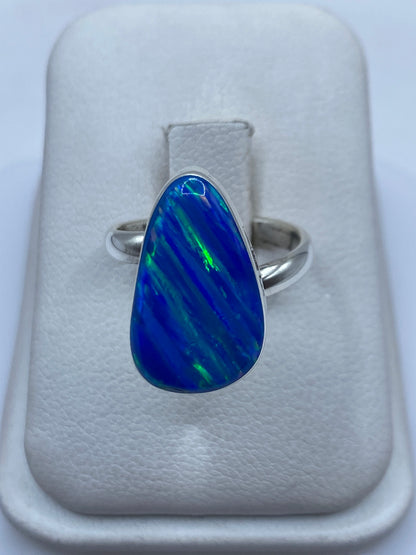 Anillo de plata .950 ajustable con ópalo de fuego azul en la mano