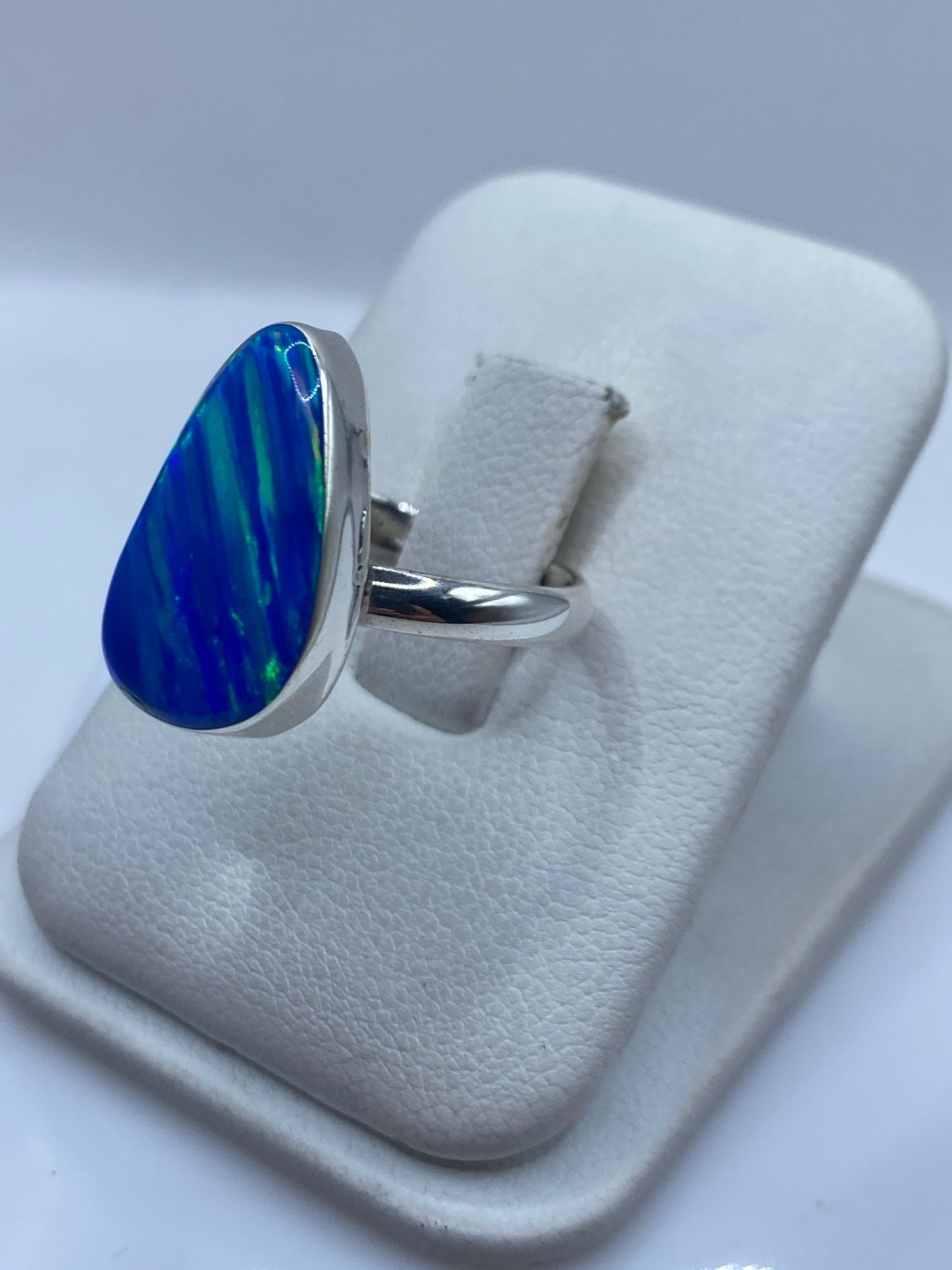 Ópalo de fuego azul con destellos verdes en anillo de plata pulida