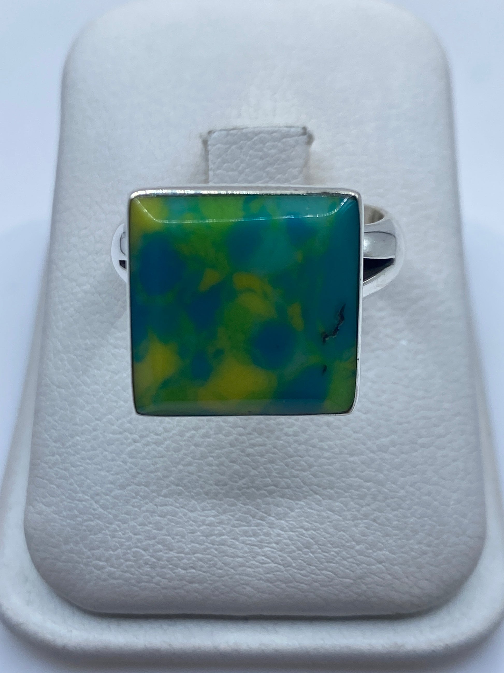 Anillo de plata .925 con piedra verde cuadrada en la mano de una mujer