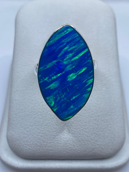 Anillo de plata con ópalo de fuego azul, vista frontal en caja blanca