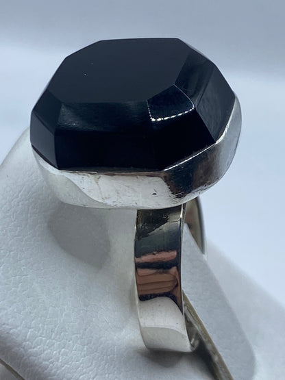 Anillo ajustable de ónix y plata en la mano mostrando el tamaño relativo