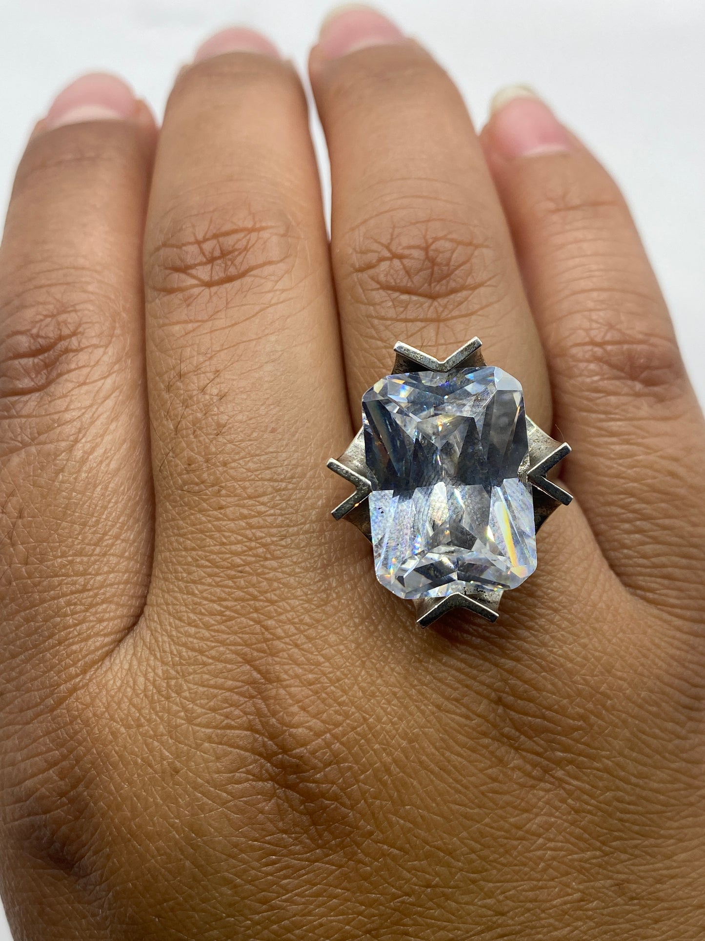 Anillo solitario brillante sobre base gris mostrando el fuego de la piedra