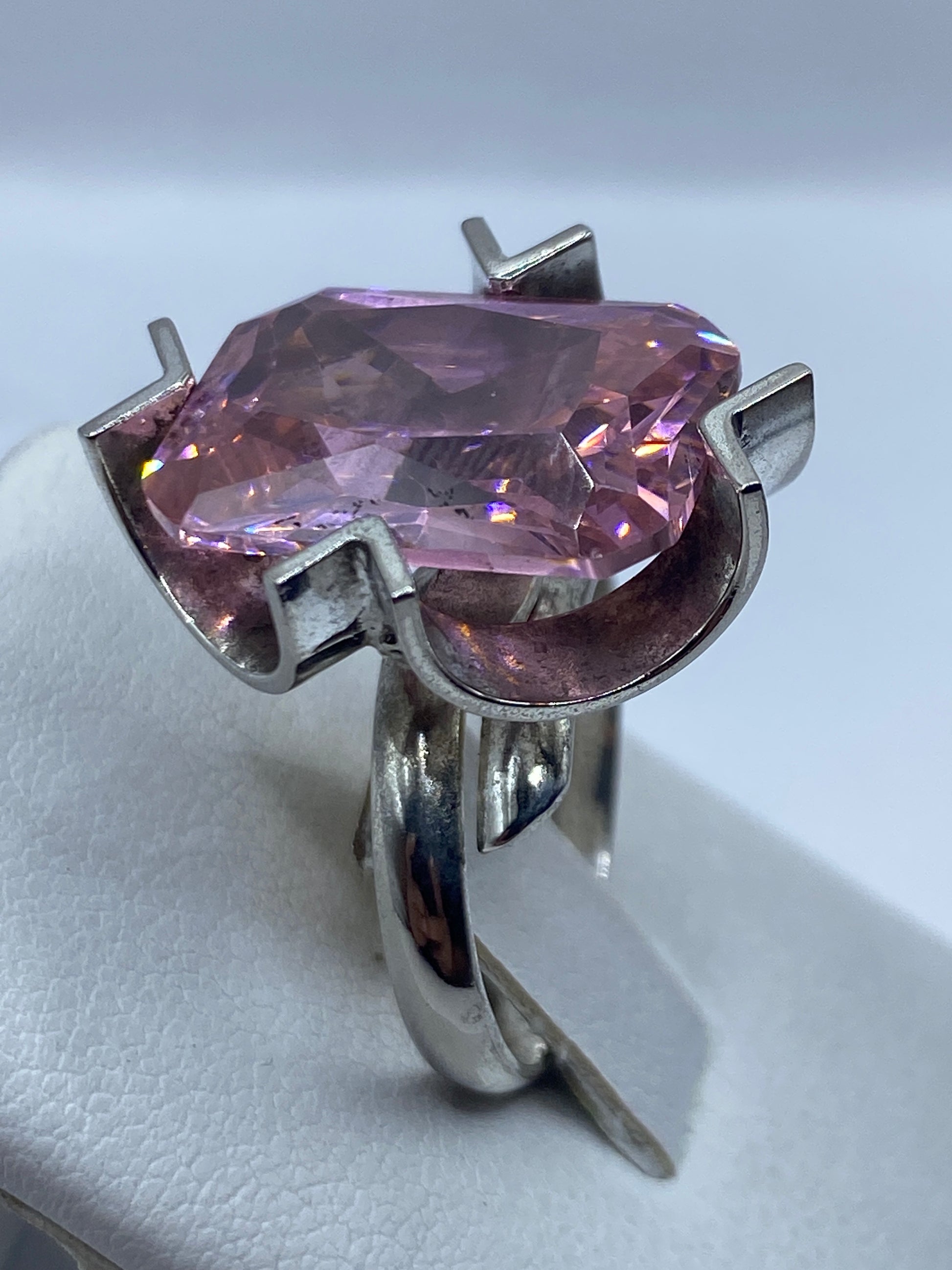 Anillo solitario rosa puesto en dedo, mostrando el brillo y fuego de la circonia