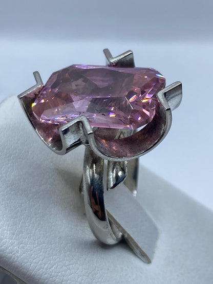 Anillo solitario rosa puesto en dedo, mostrando el brillo y fuego de la circonia