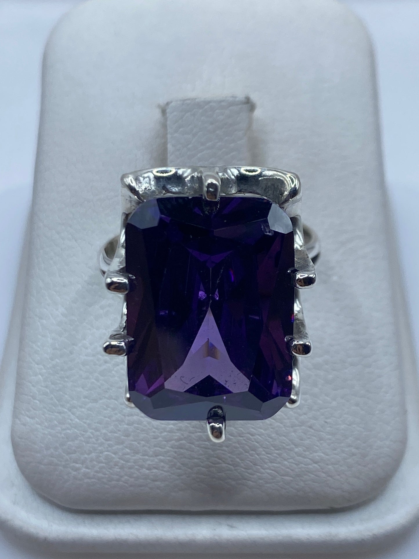 Anillo de plata solitario con circonia morada facetada en engaste envolvente