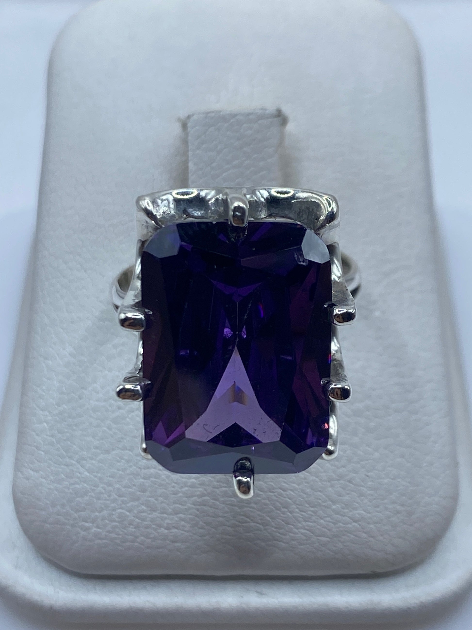 Anillo de plata solitario con circonia morada facetada en engaste envolvente