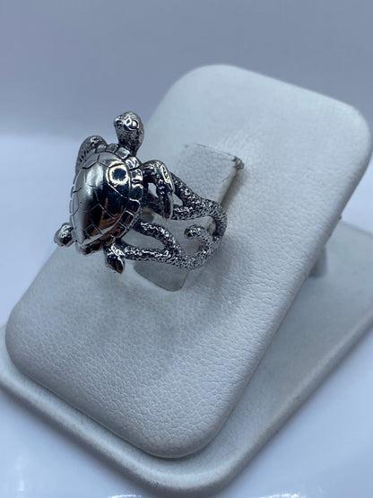 Anillo tortuga en plata .950 puesto en dedo, detalle de la textura grabada y el pulido brillante