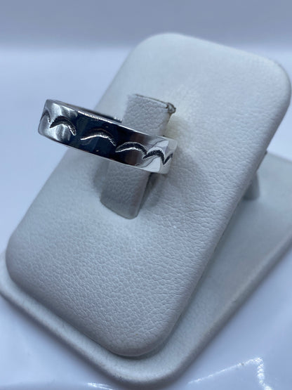 Vista lateral del anillo unisex mostrando el grabado profundo de ondas