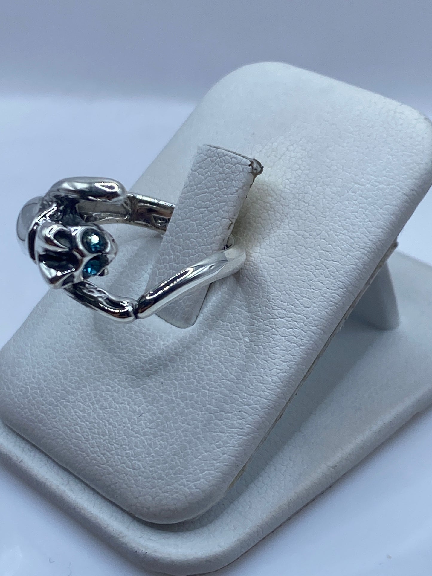 Detalle lateral del anillo mano con circonia azul brillante en plata .925