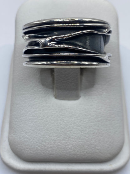 Anillo de plata con bandas superpuestas en posición horizontal sobre fondo blanco