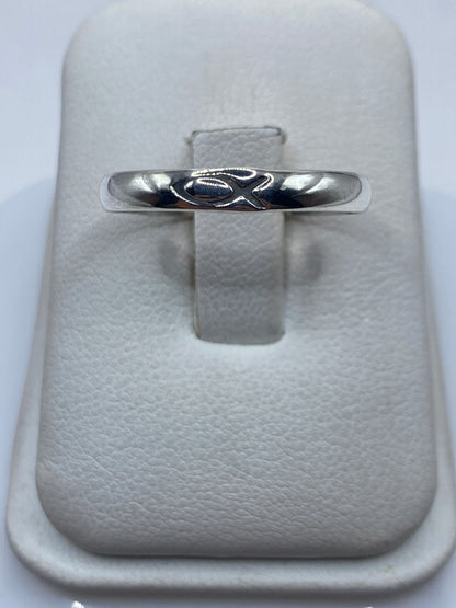 Anillo de plata banda pulida minimalista en la mano de una persona
