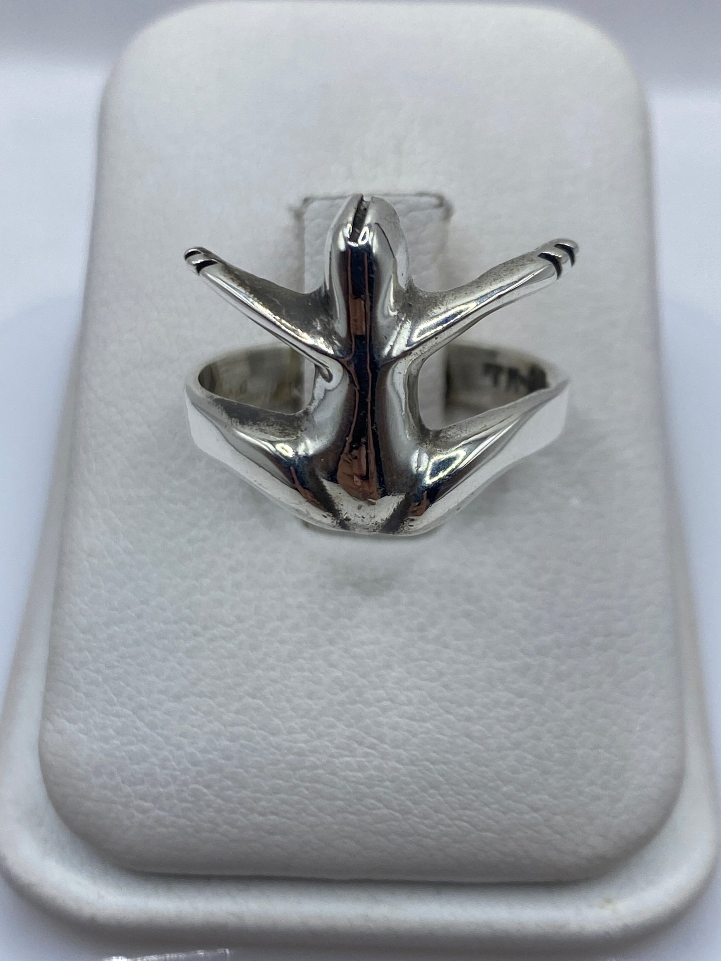 Anillo de plata .925 con diseño ala minimalista en forma abierta sobre anillo de presentación