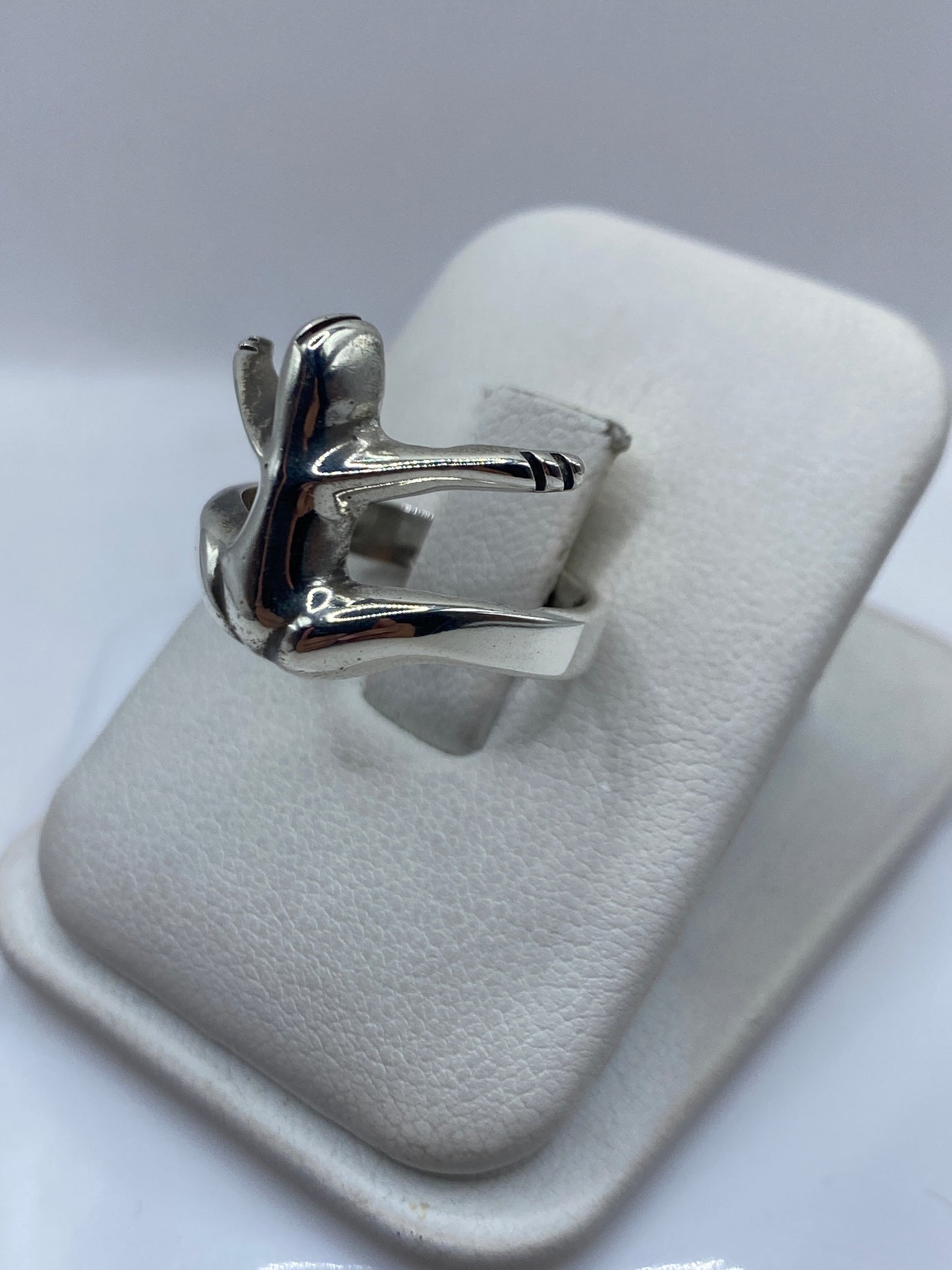 Vista lateral del anillo escultural ala en plata pulida brillante