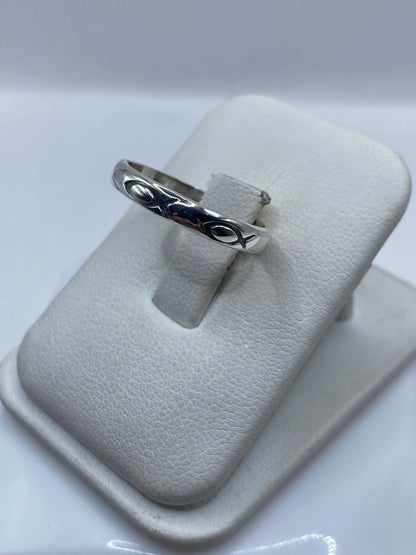 Anillo minimalista de plata en la mano, mostrando el diseño liso y pulido