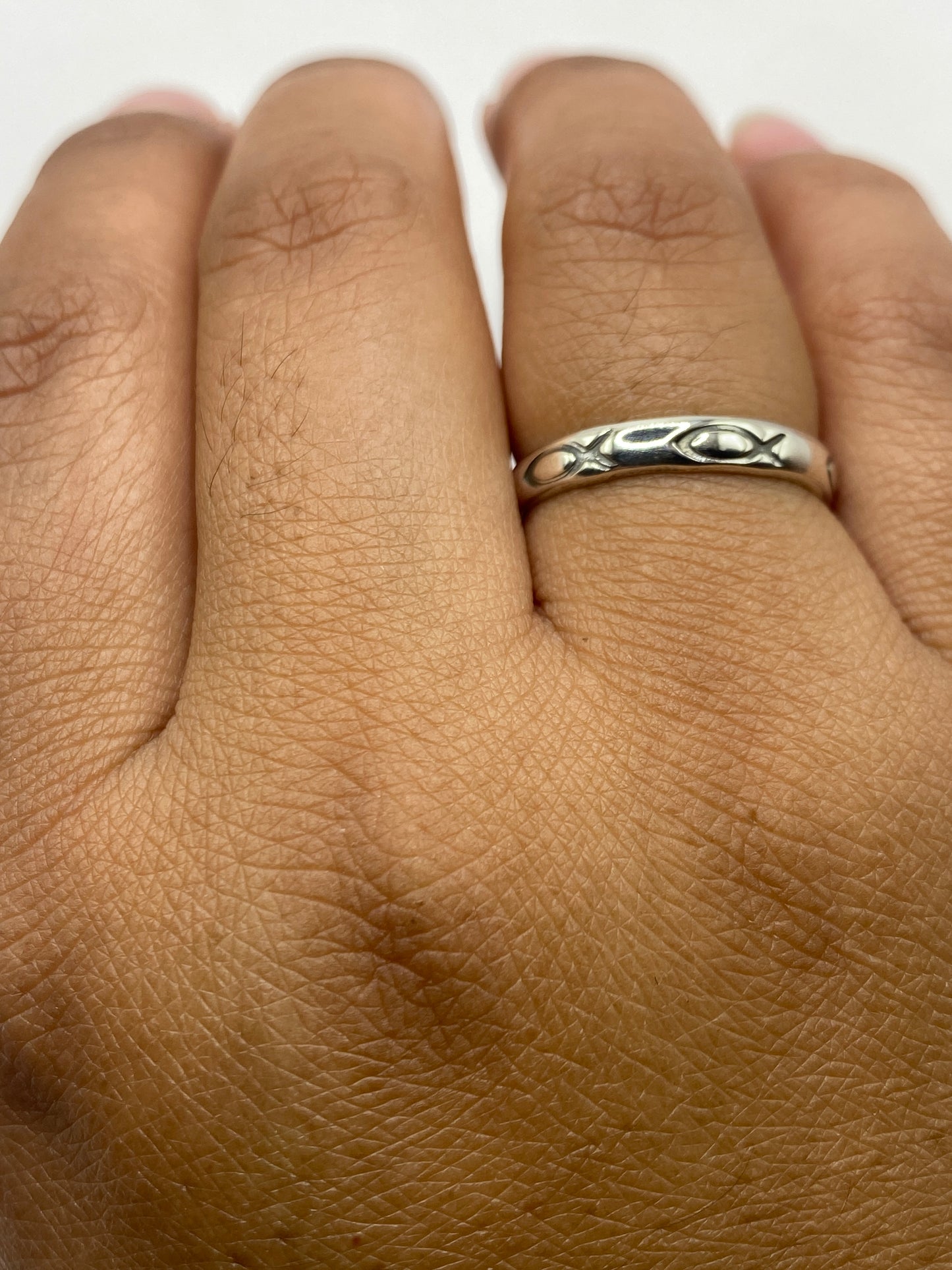 Anillo de plata sobre fondo gris, mostrando proporciones y acabado brillante