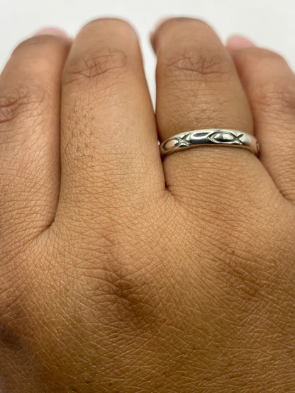 Anillo de plata sobre fondo gris, mostrando proporciones y acabado brillante