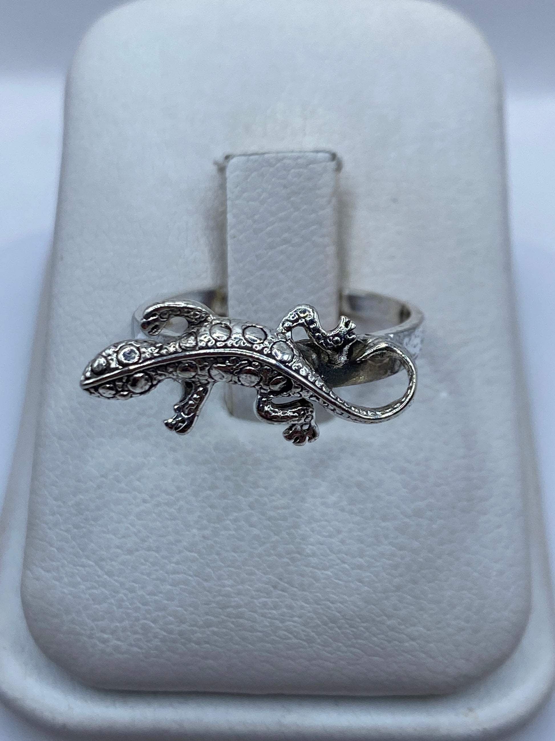 Anillo de plata artesanal con figura de iguana en relieve, sobre estuche blanco