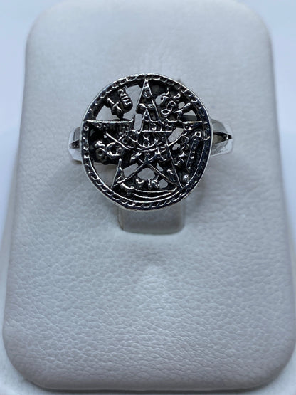 Anillo de plata con símbolo prehispánico tallado, vista frontal sobre anillo de presentación blanco