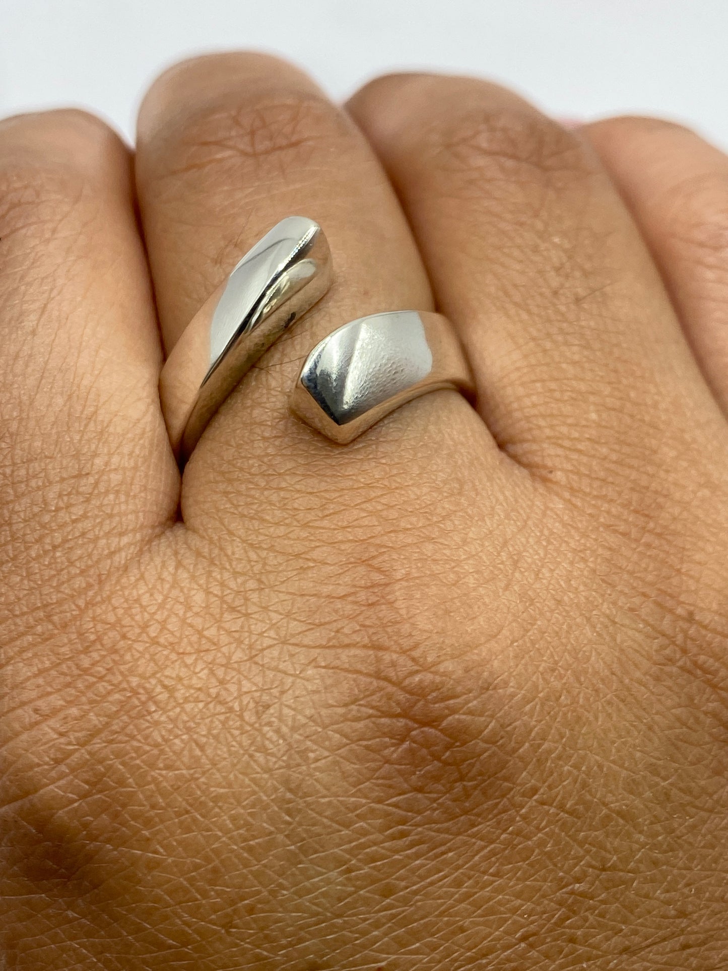 Anillo ajustable de plata en mano, evidenciando comodidad y peso generoso