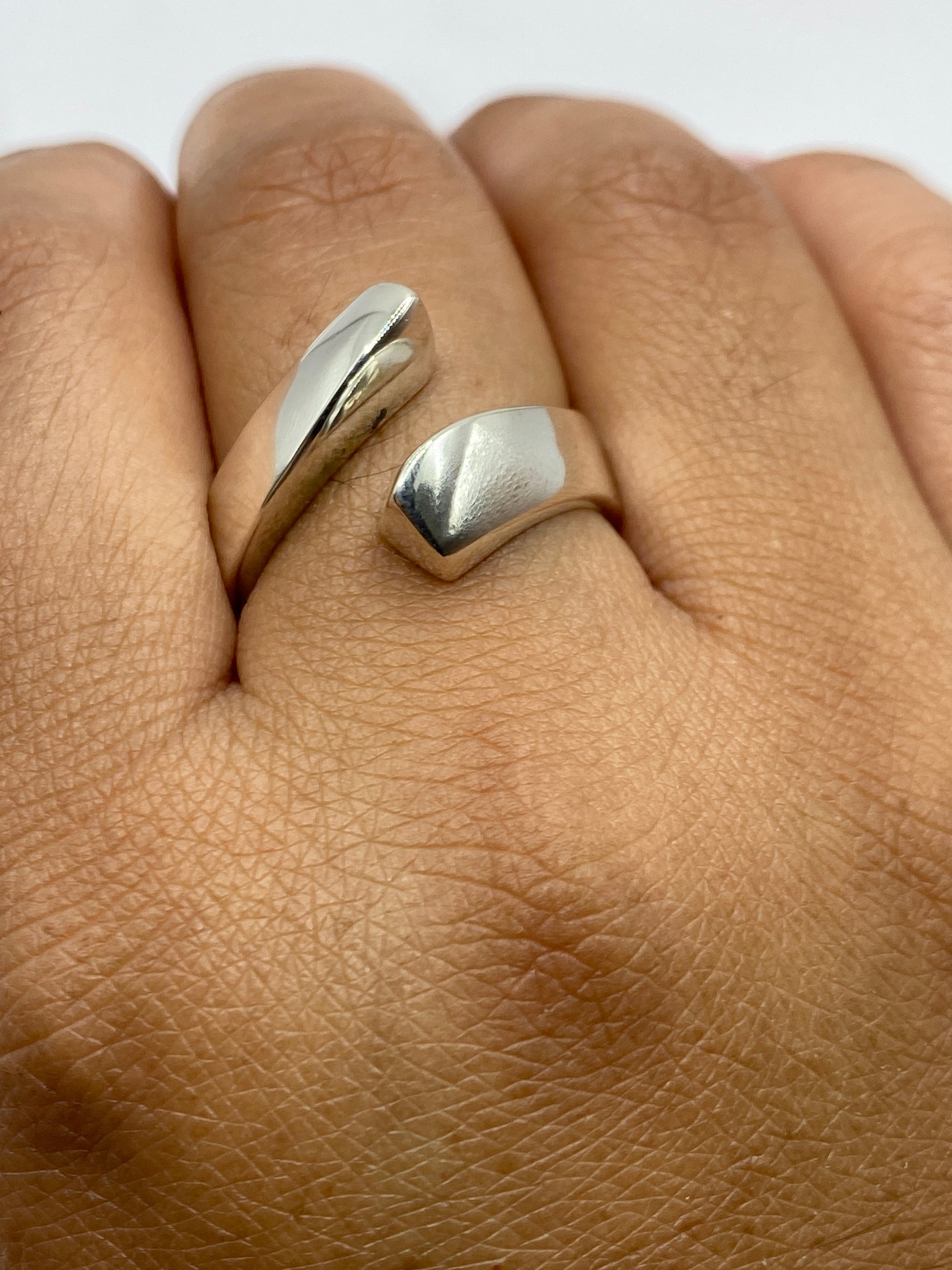 Anillo ajustable de plata en mano, evidenciando comodidad y peso generoso