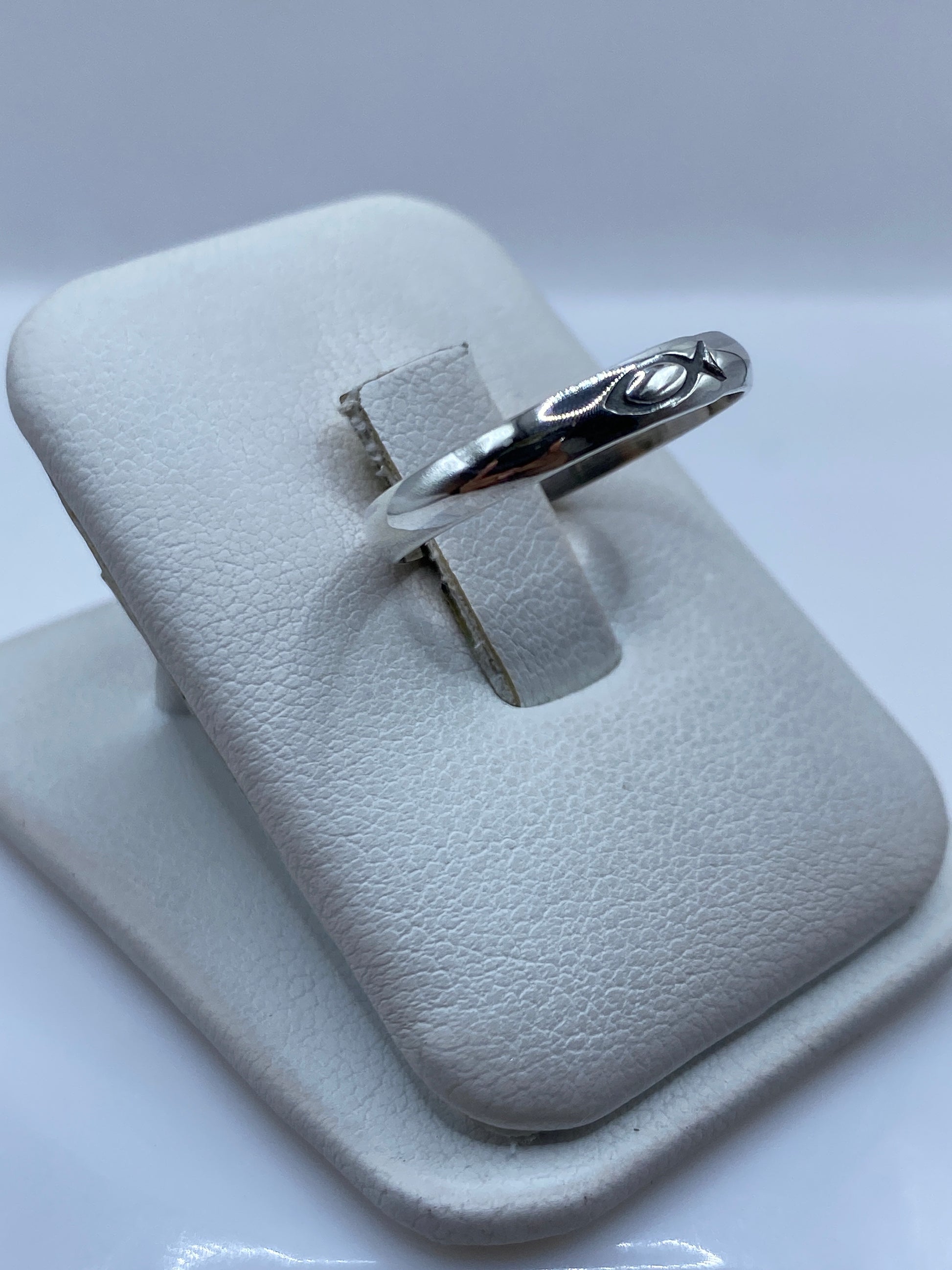 Anillo minimalista de plata en vista lateral mostrando el pulido y el sello 925