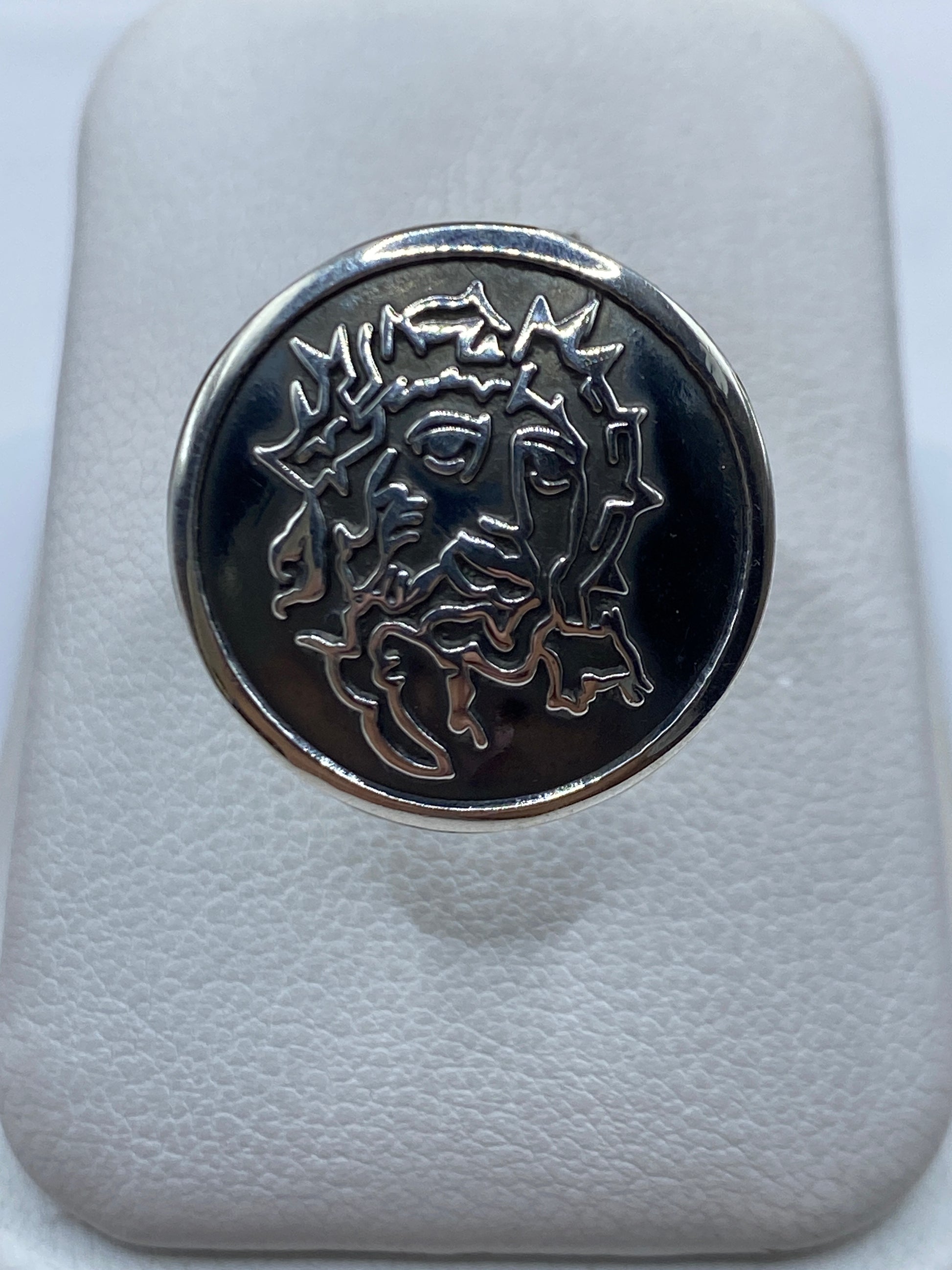 Anillo de plata sello ovalado grabado en alto relieve, vista frontal sobre fondo blanco