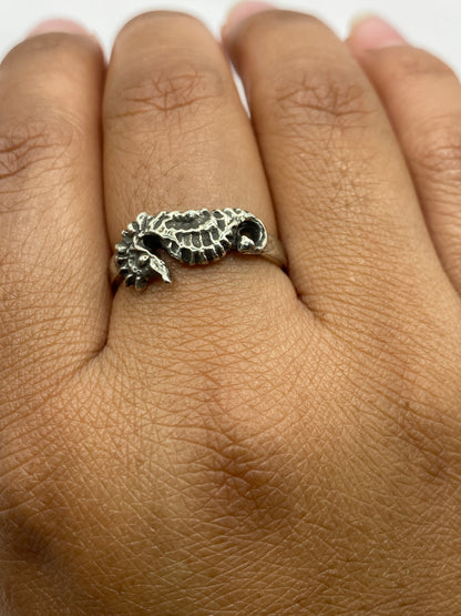 Anillo sobre fondo gris neutro con reflejo de luz en el pulido de plata .925
