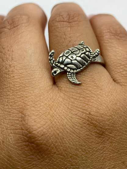 Anillo tortuga puesto en dedo, mostrando el símbolo de protección ancestral