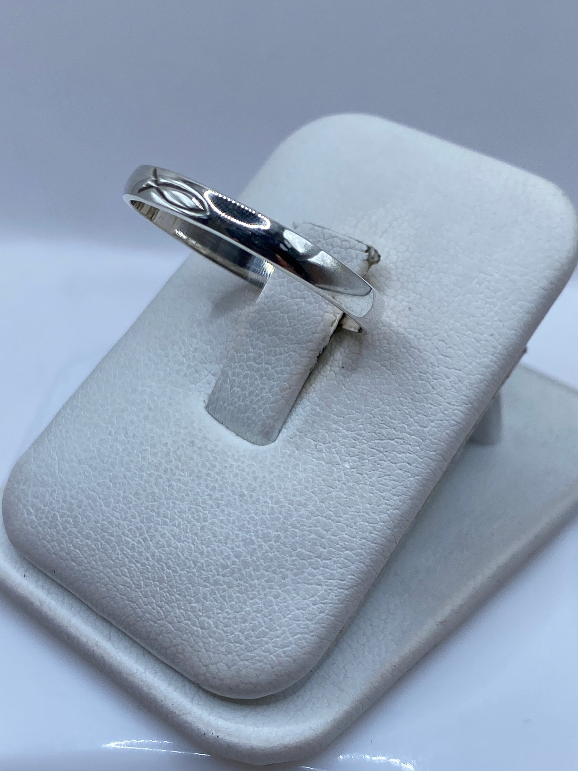 Anillo minimalista de plata en dedo de mujer, mostrando el acabado pulido