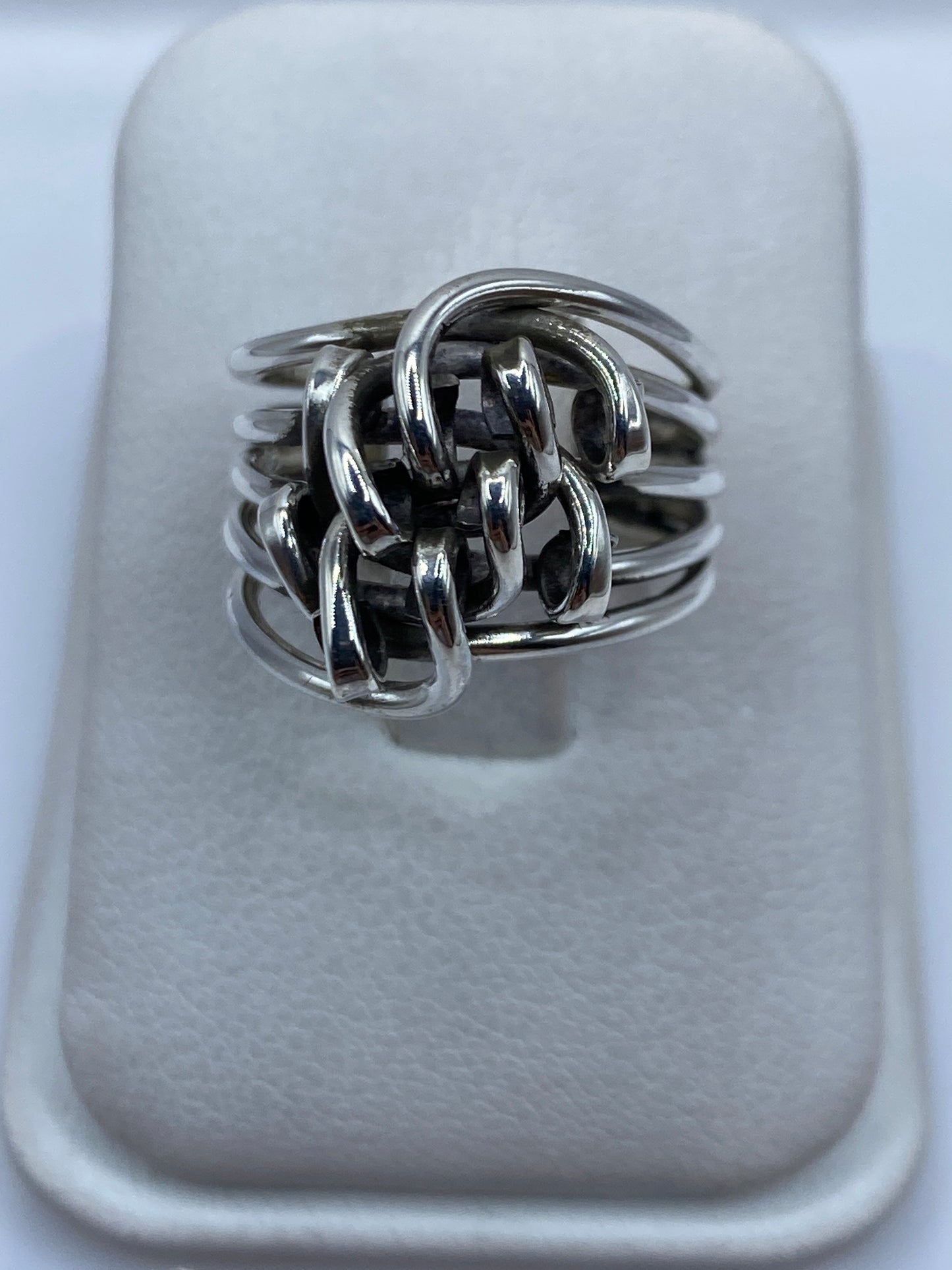 Anillo de plata arquitectónico entrelazado en la mano de una mujer