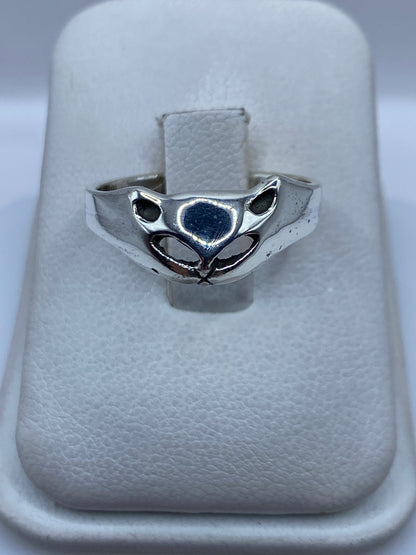 Anillo de plata con cara de gato minimalista en los ojos abiertos sobre estuche blanco